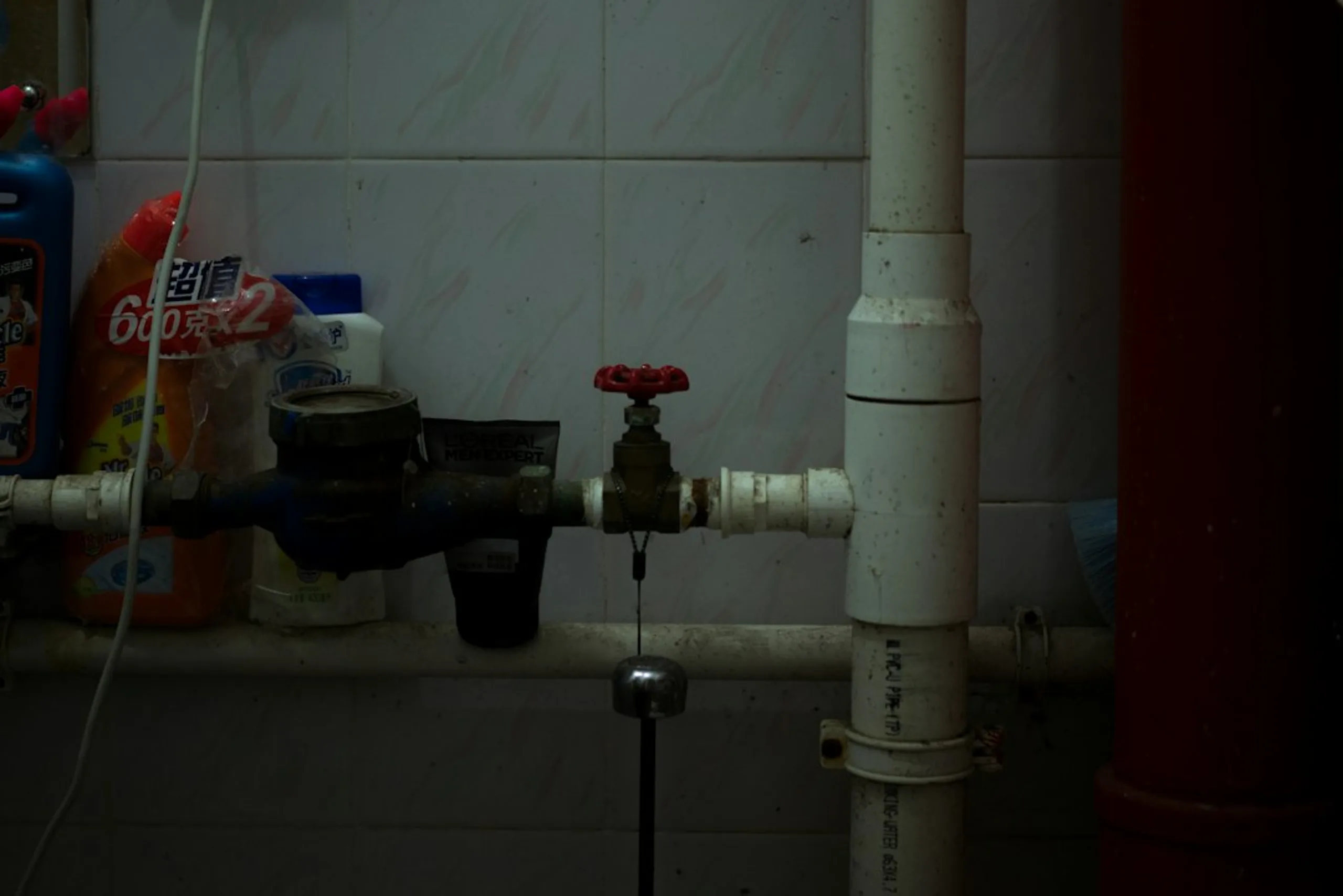 Sortie d'évacuation d'un lavabo dans un mur de salle de bains, raccordée au siphon