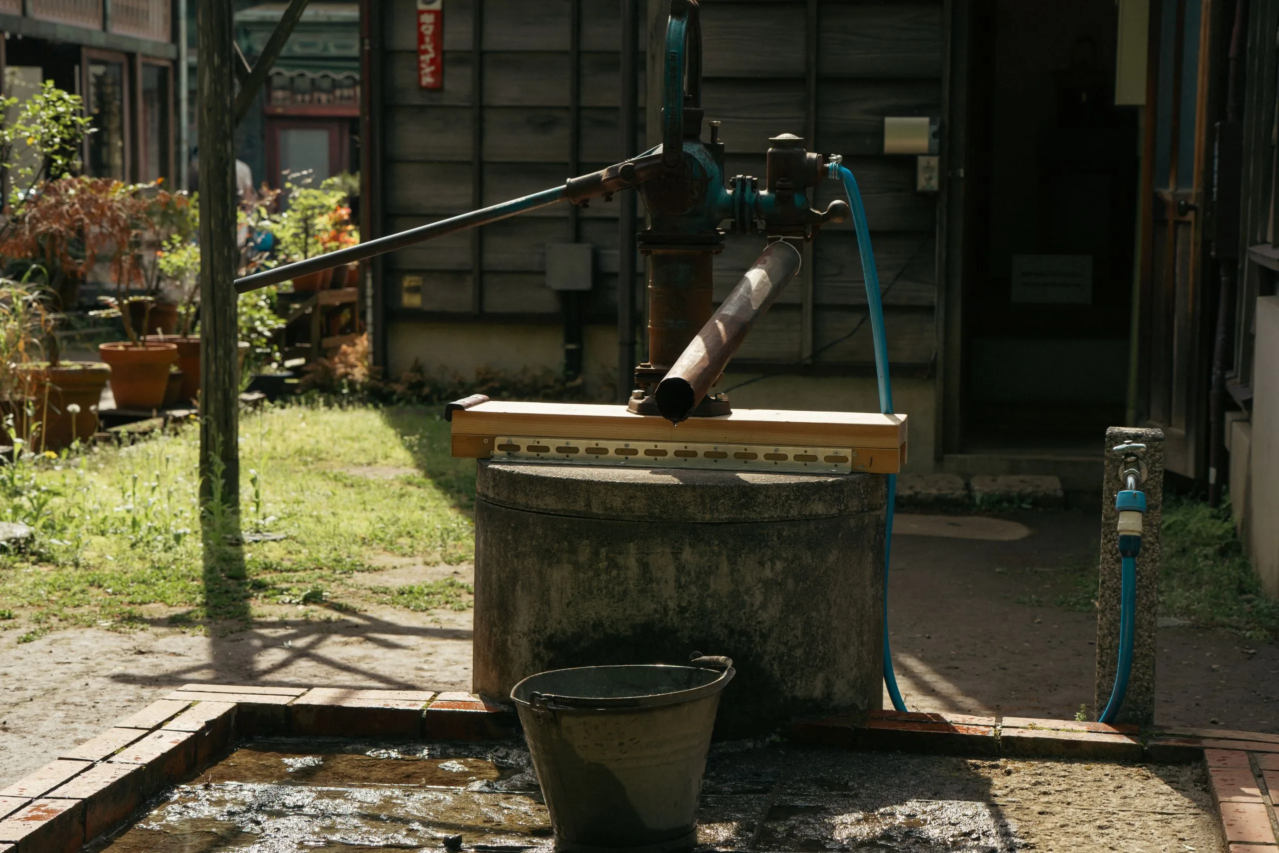 Pompe à main en fonte à levier installée dans un jardin
